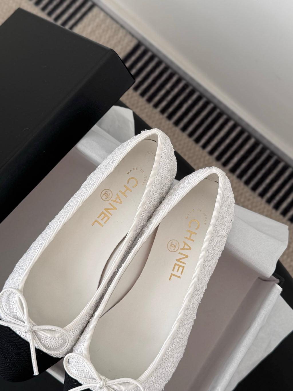 Two-tone ballet flats showing interior and logo on insole, bow-tied lace closure