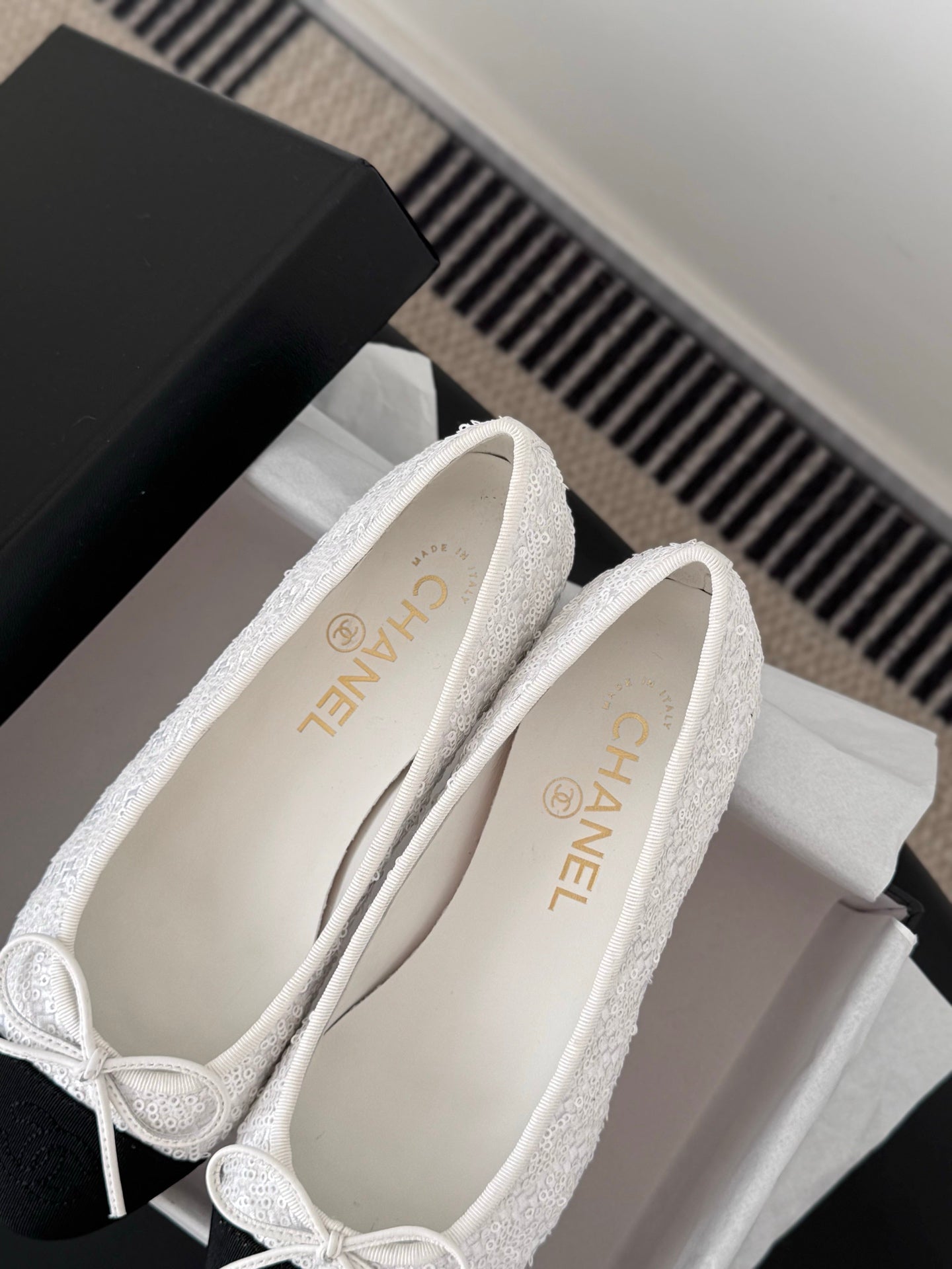 Two-tone ballet flats showing interior and logo on insole, bow-tied lace closure