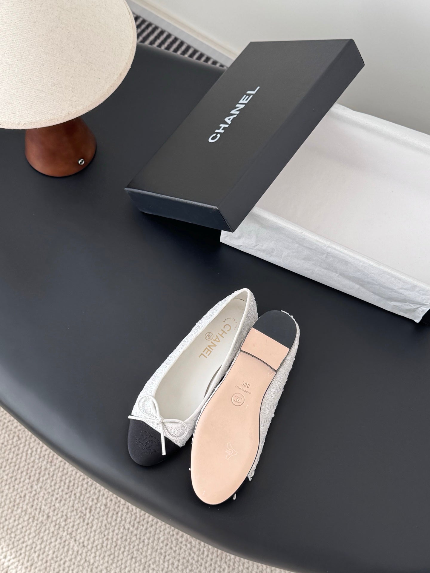 Two-tone ballet flats with white textured uppers and dark toe with bow laces
