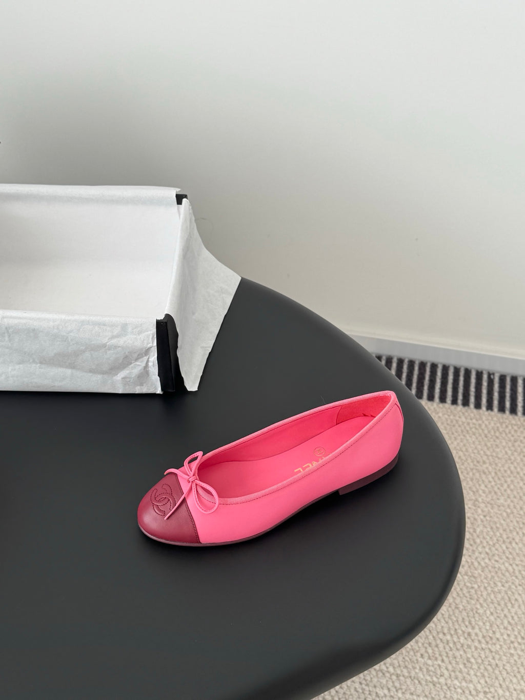 Pink Chanel ballet flat with bow at toe, shown single shoe side view