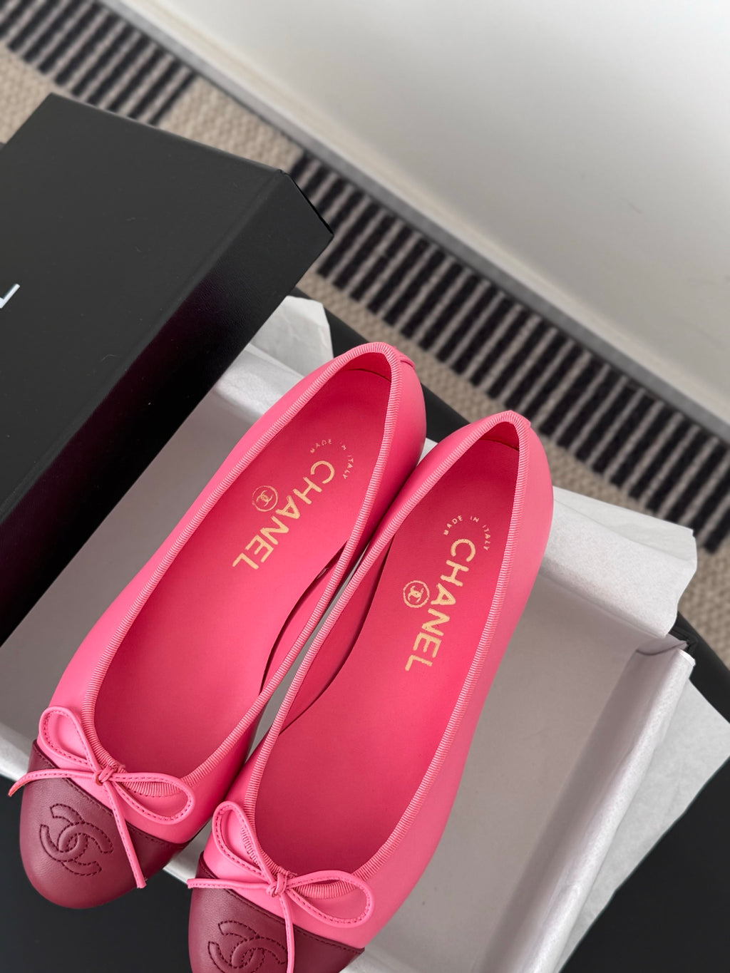 Pink Chanel ballet flats with ribbon bow; inner branding visible