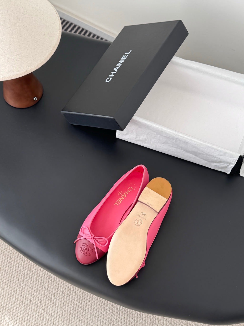 Pink Chanel ballet flats with bow; tan outsole visible on one shoe