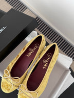 Women's gold ballet flats with ribbon bow and purple CHANEL insole, side view