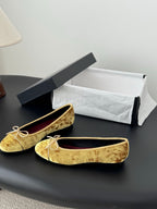 Pair of women's gold ballet flats with ribbon ties and cushioned round toe