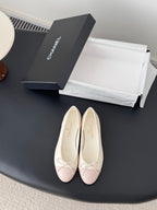 Pair of pale pink ballet flats with white laces and bow detail on toe.