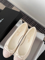 Pair of ballet flats with pale pink toe sections and white laces, close-up angle.