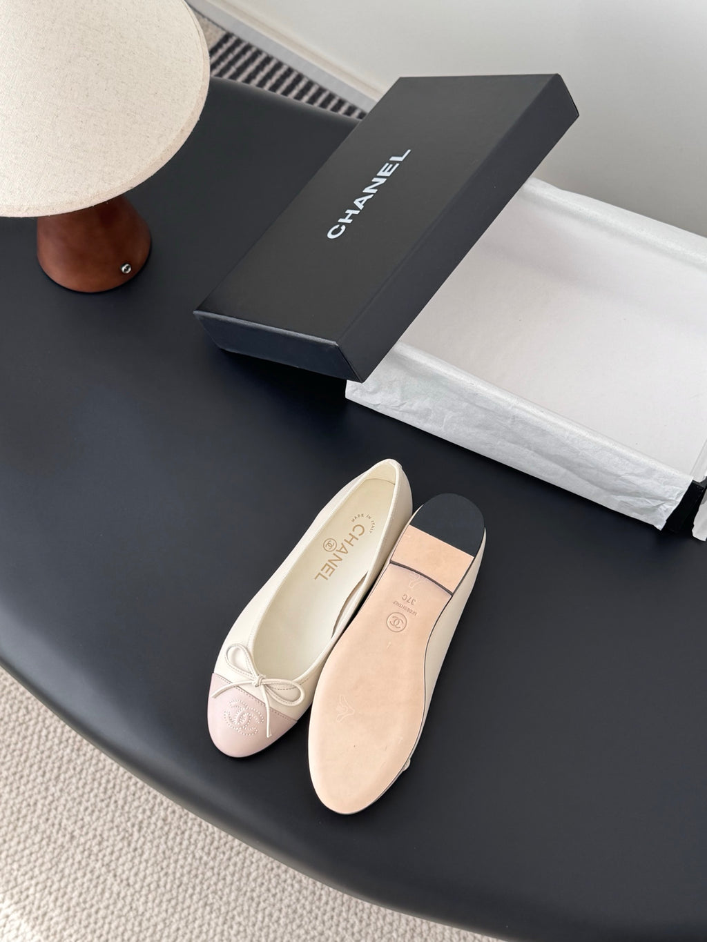 Pale pink and cream ballet flats with lace-up bow and cushioned sole, side view.