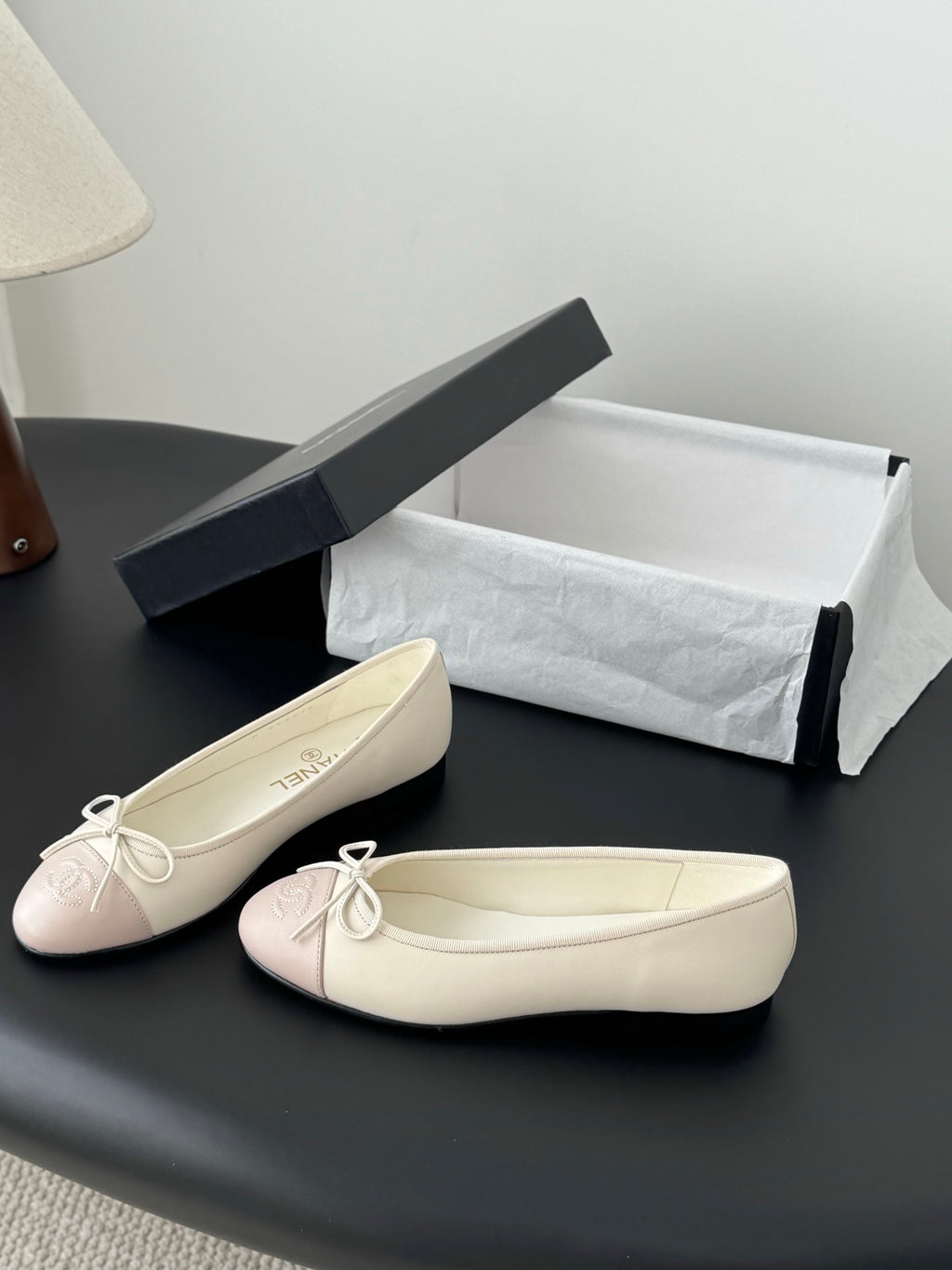 Cream and pale pink ballet flats with tied bow at the toe, shown side-by-side.