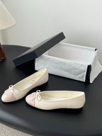 Cream and pale pink ballet flats with tied bow at the toe, shown side-by-side.