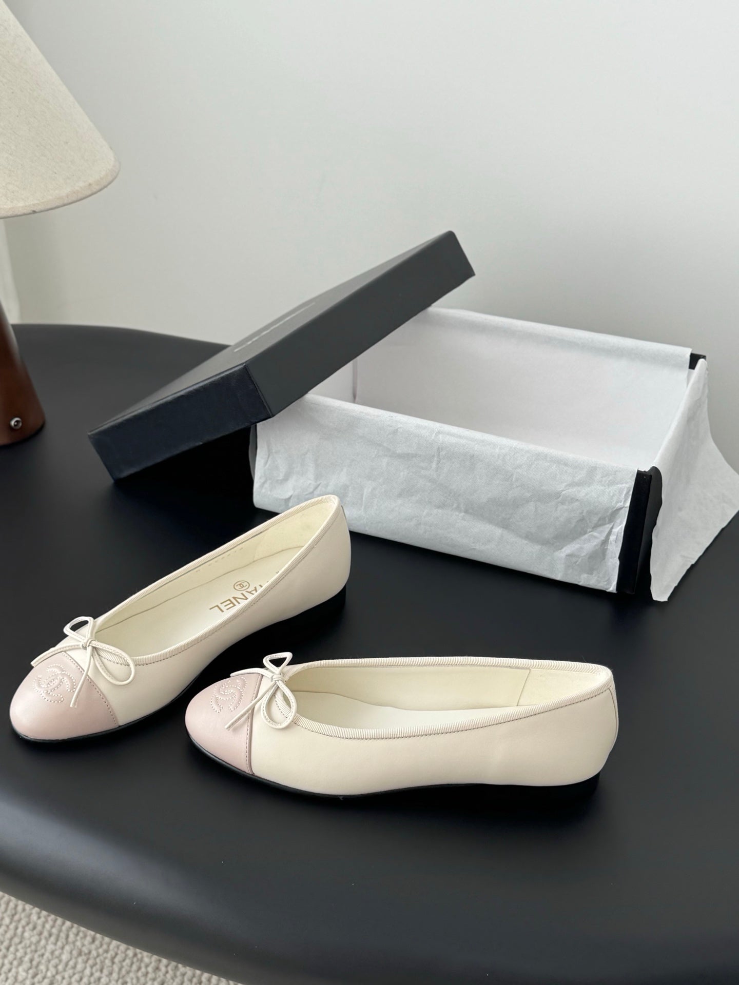 Cream and pale pink ballet flats with tied bow at the toe, shown side-by-side.