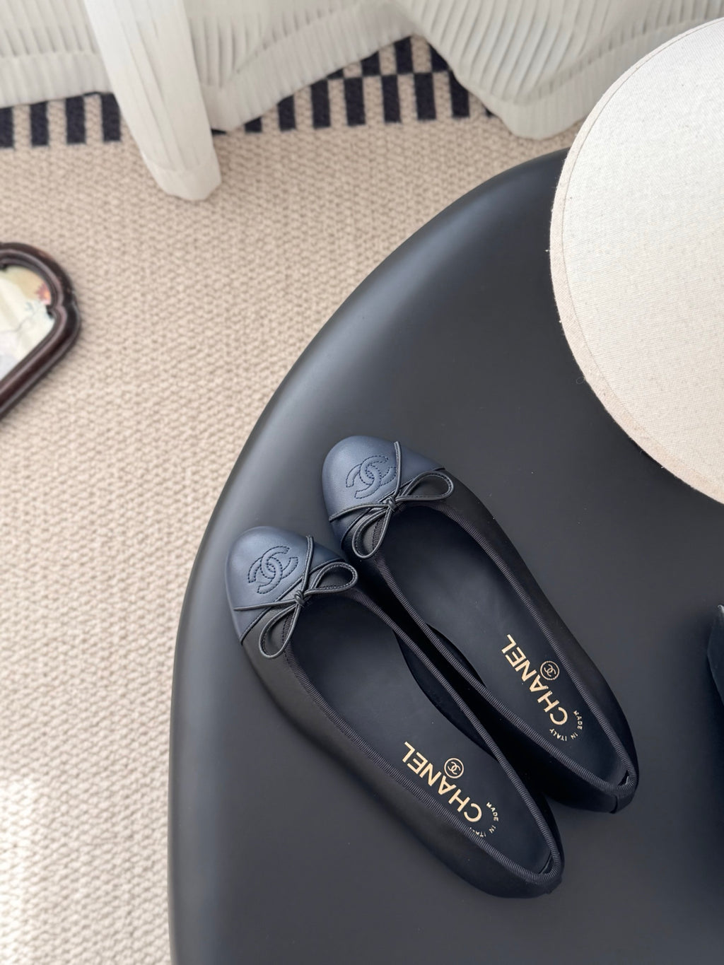 Pair of dark ballet flats with ribbon bow and CHANEL logo on insoles