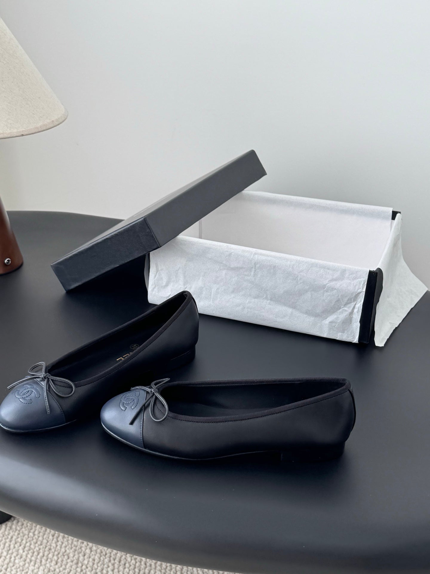 Pair of dark ballet flats with ribbon bow and rounded toe