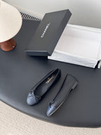 Pair of dark CHANEL ballet flats with ribbon bow and round toe
