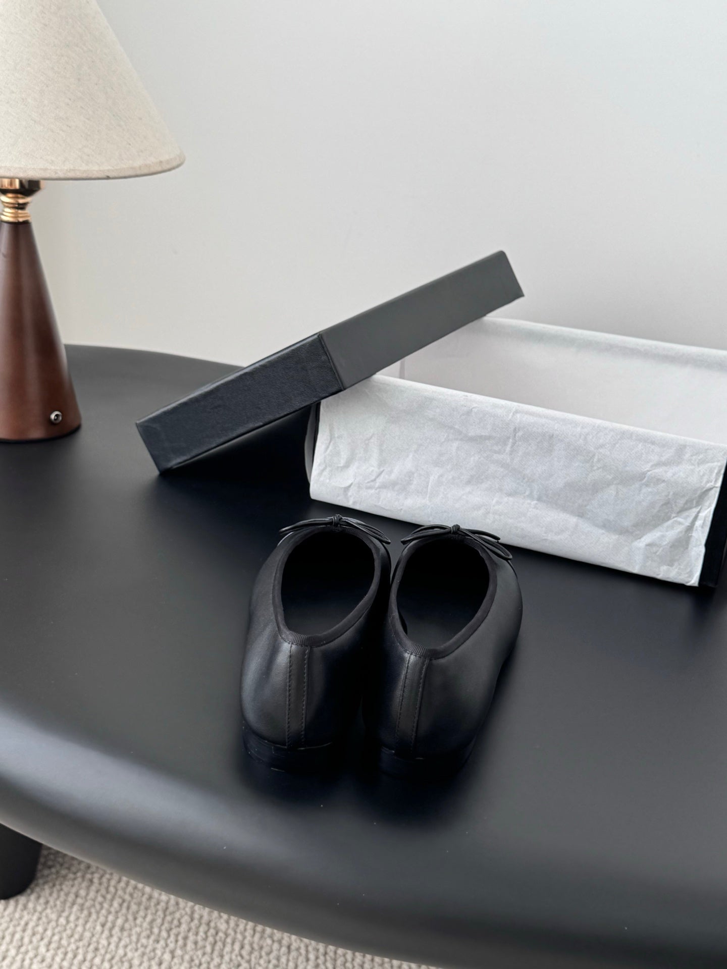 Pair of dark ballet flats with ribbon bow and rounded toe