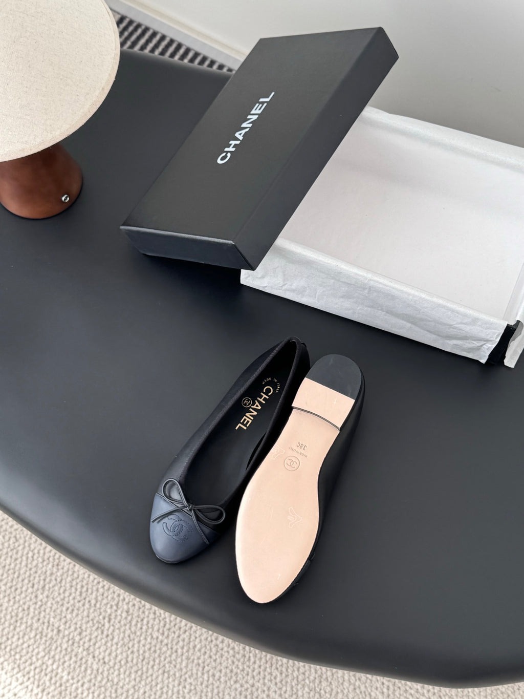 Dark CHANEL ballet flats with ribbon bow and rounded toe, showing light insole