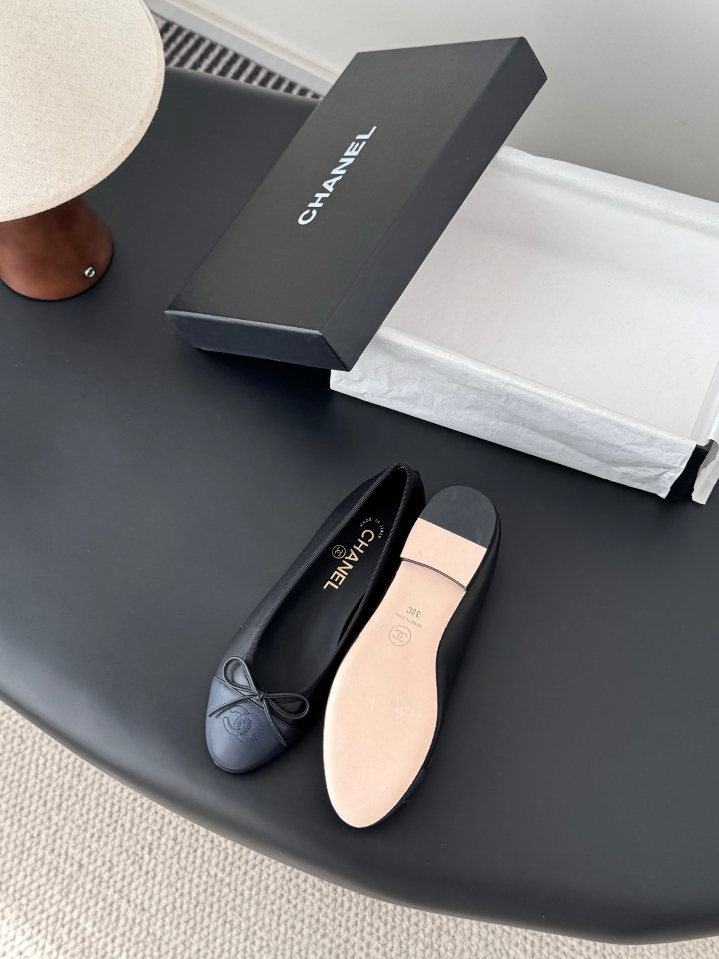 Dark CHANEL ballet flats with ribbon bow and rounded toe, showing light insole