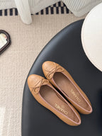Tan Chanel ballet flats with bow and embossed logo on upper