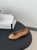 Tan Chanel ballet flat with bow and embossed logo on toe