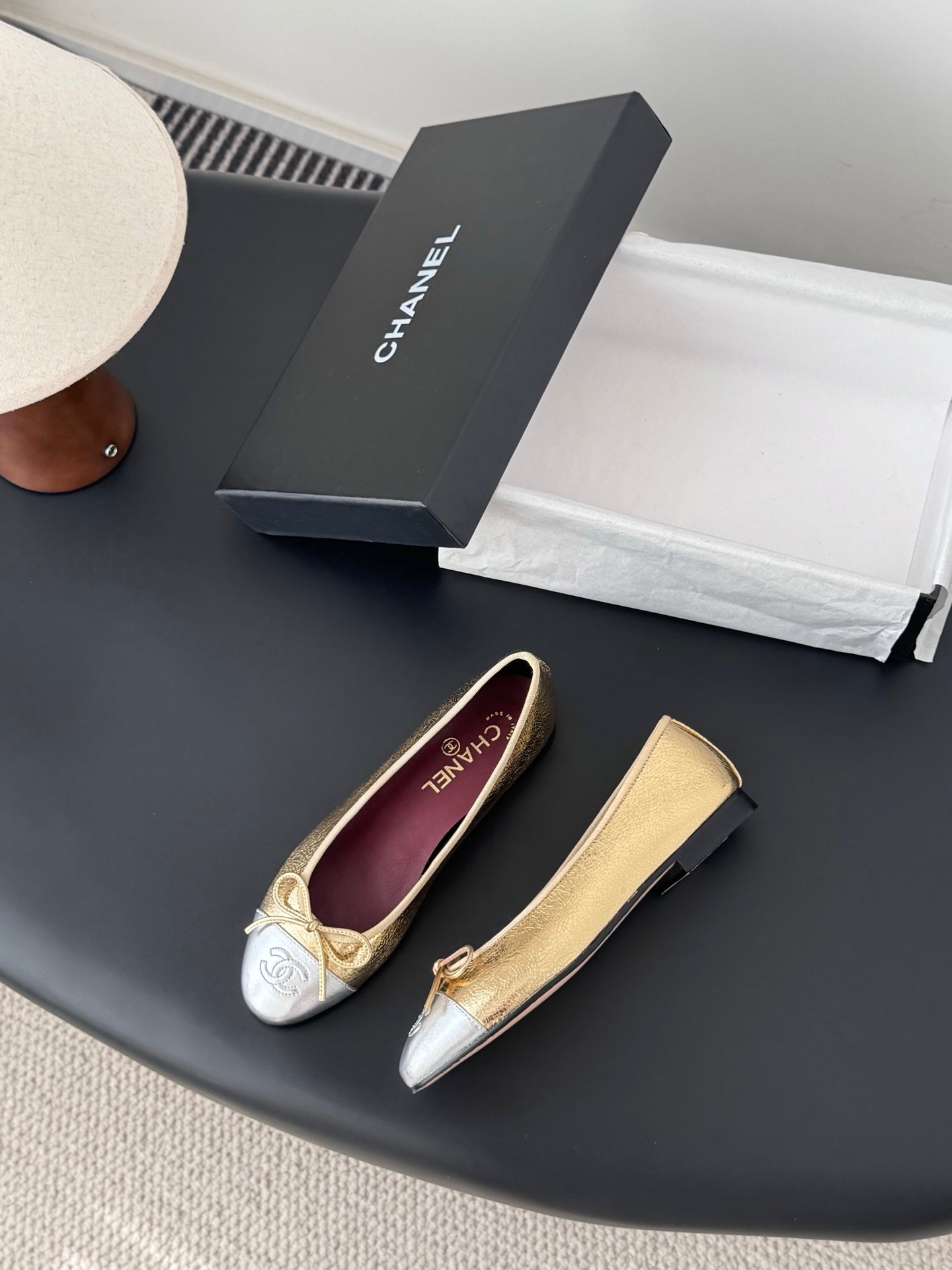 Pair of two-tone ballet flats with round toe, bow ties, and Chanel logos