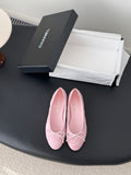 Pink ballet flats with bow ties, textured upper, rounded toe