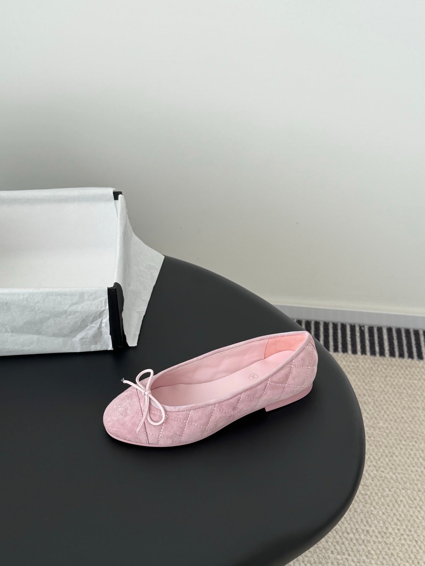 Pink ballet flat with bow laces and textured fabric upper, rounded toe