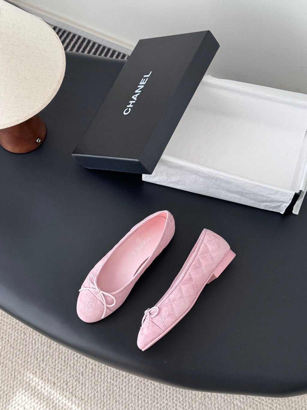 Pair of pink ballet flats with bow tie detailing and rounded toe