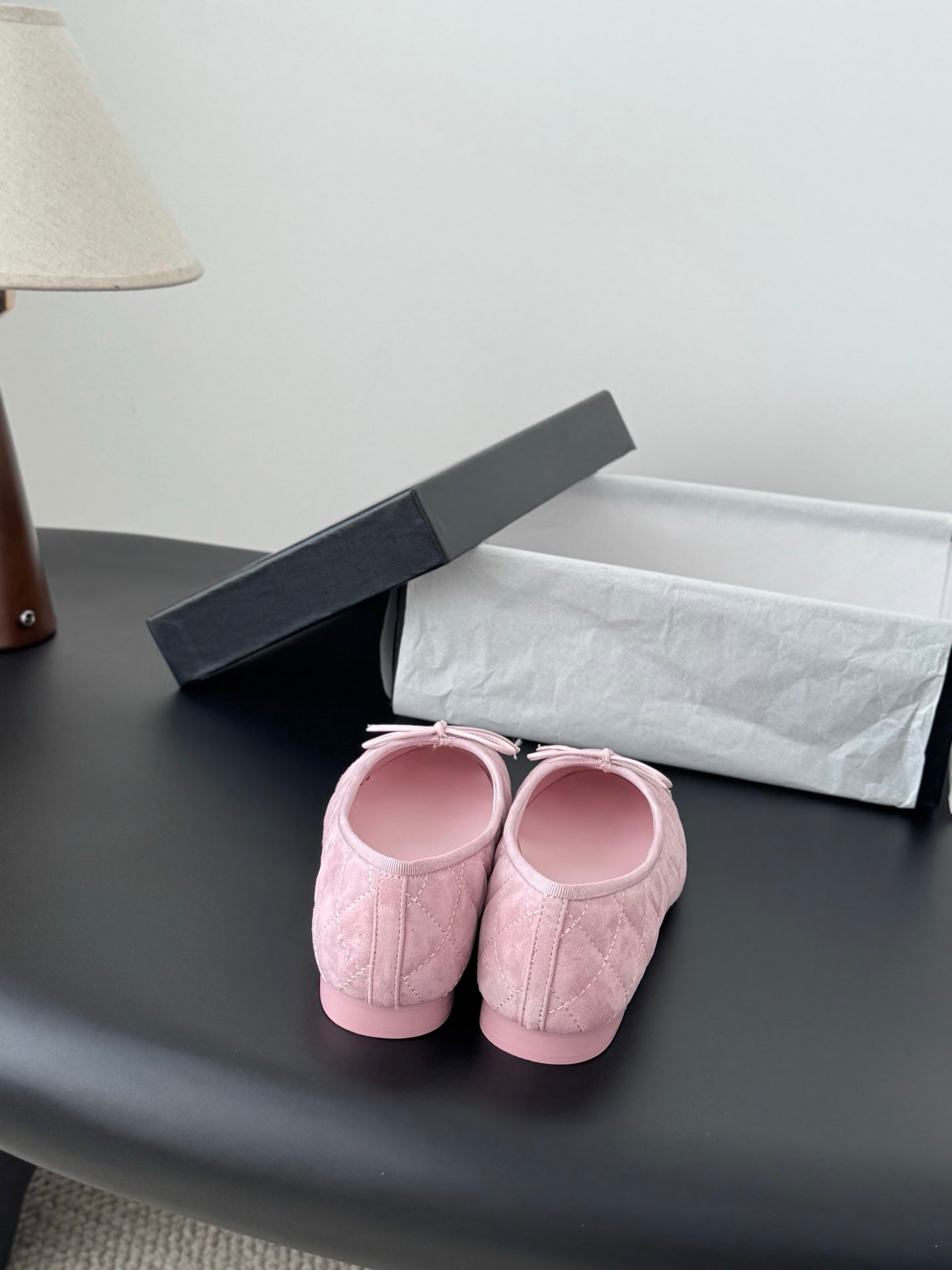 Pink ballet flats with bow ties on textured uppers, rounded toe