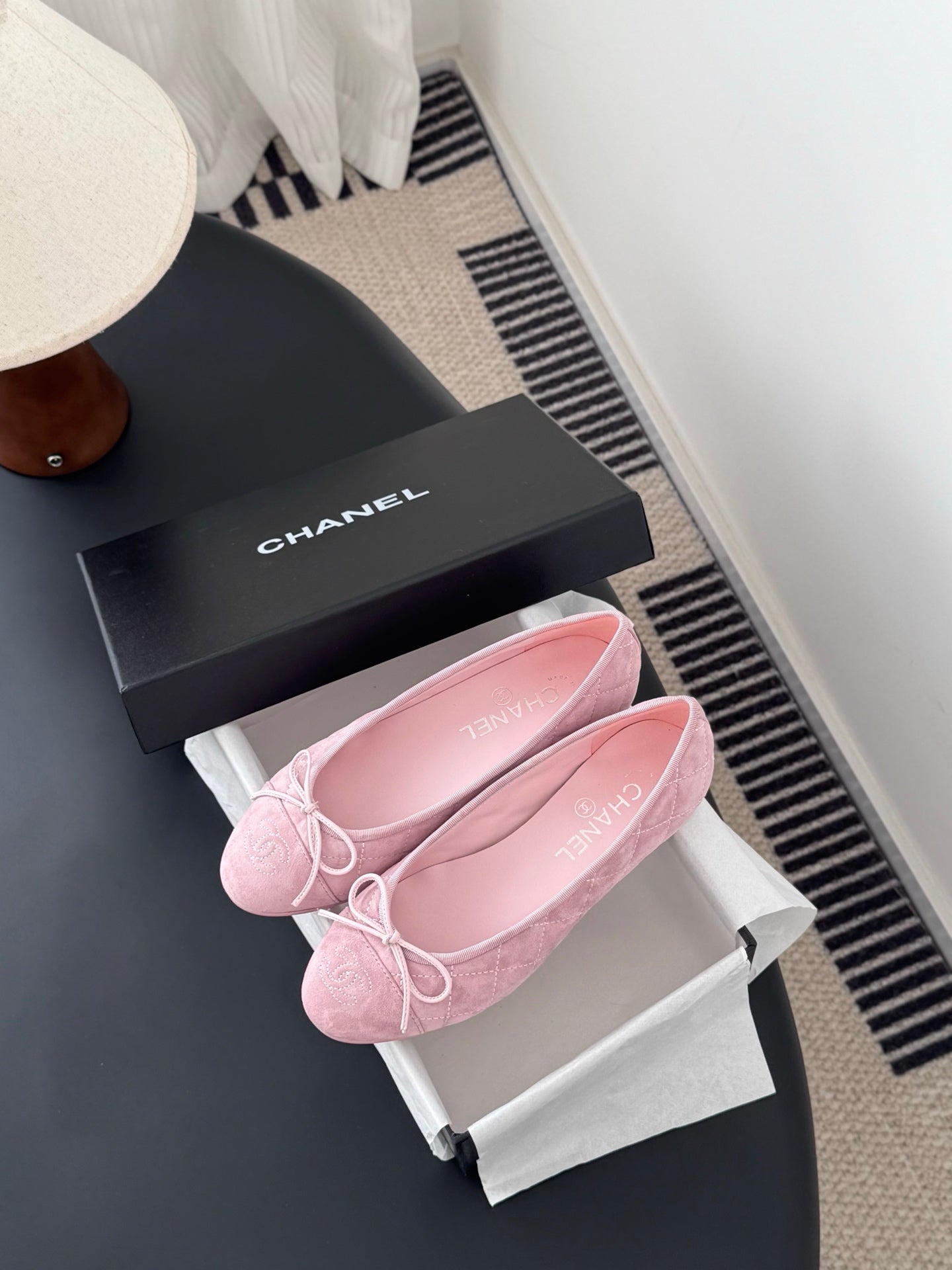 Pink ballet flats with bow laces inside white shoe box