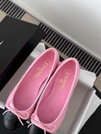 Chanel pink ballet flats with bow, black toe caps, and open insole view