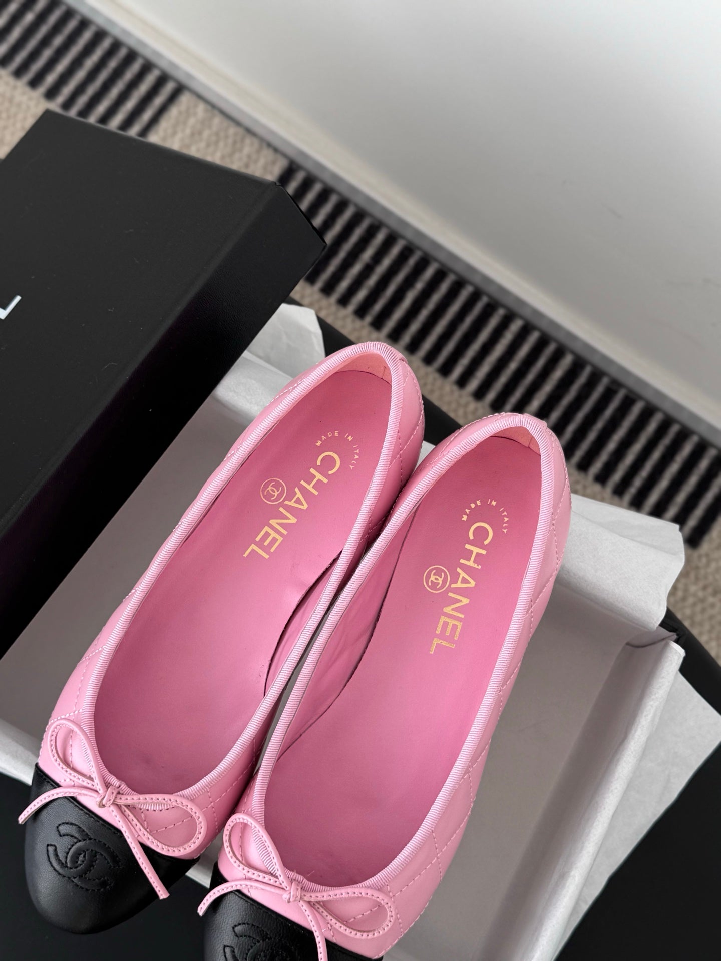 Chanel pink ballet flats with bow, black toe caps, and open insole view