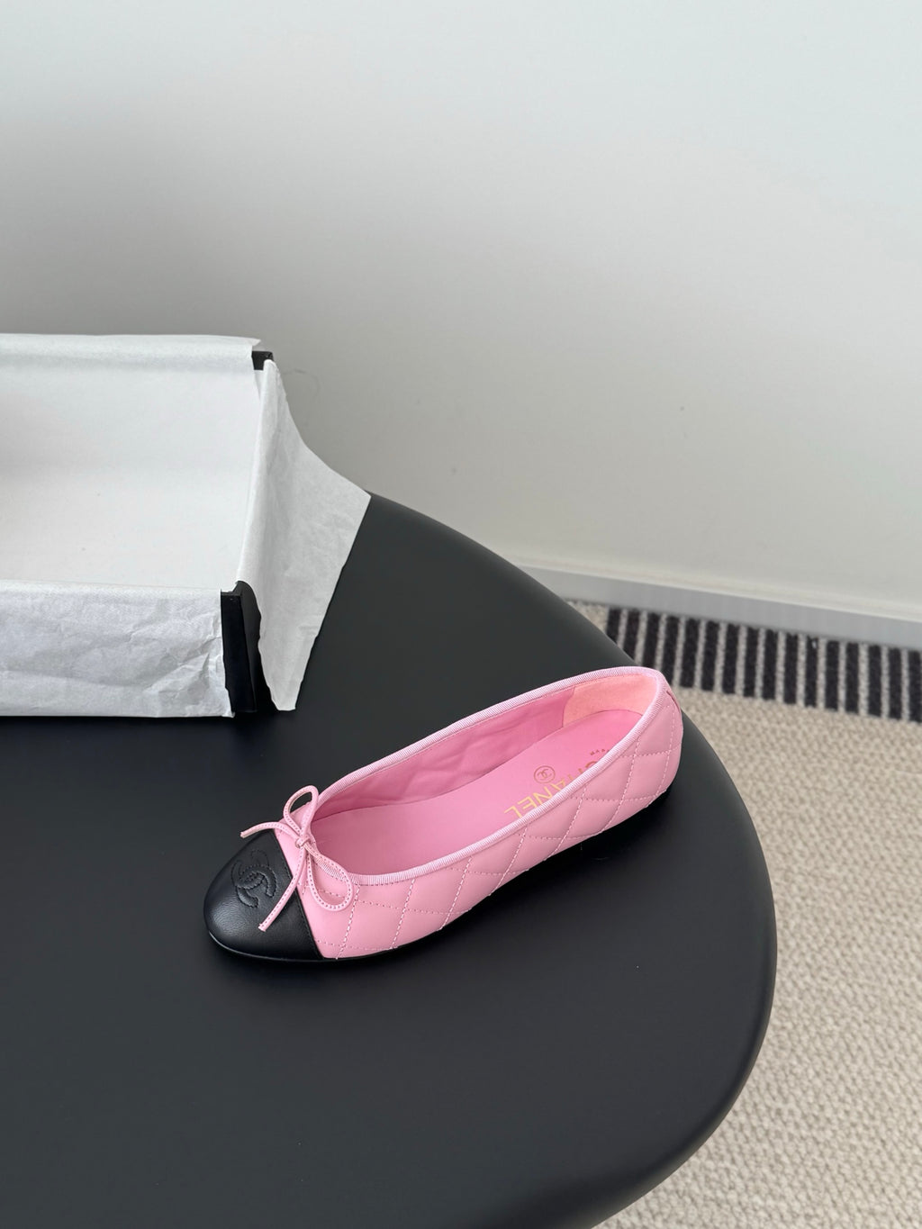 Single Chanel pink ballet flat with tied bow and black toe cap