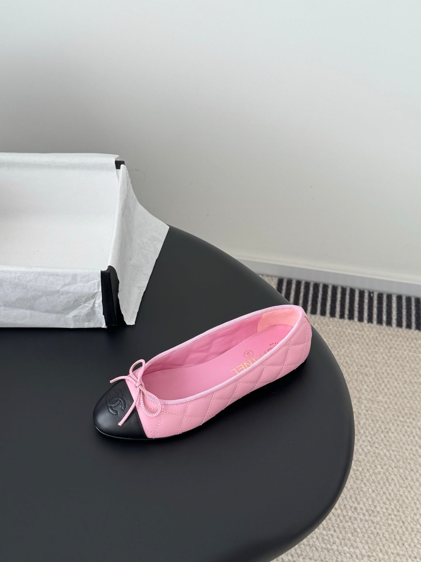 Single Chanel pink ballet flat with tied bow and black toe cap