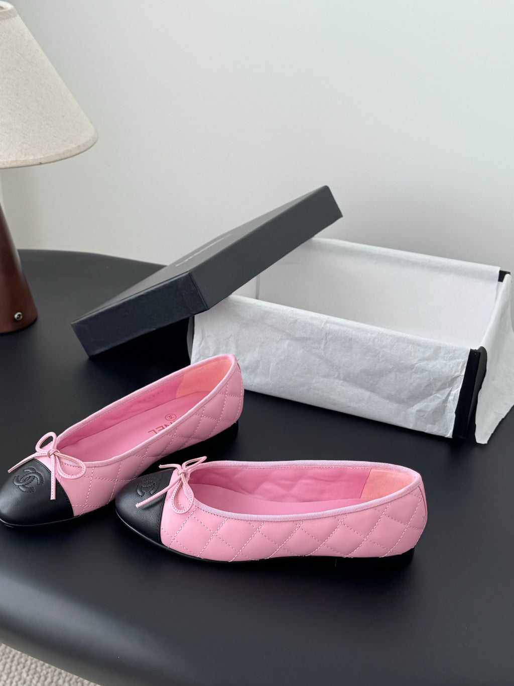 Pair of Chanel pink quilted ballet flats with black toe caps and tied bow