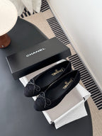 Women's dark ballet flats with lace-up bows, Chanel branding on insole