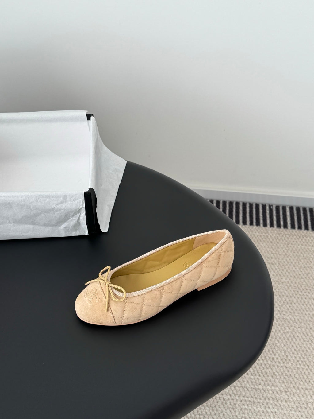 Beige quilted ballet flat with bow at toe, round toe and lightly padded sole