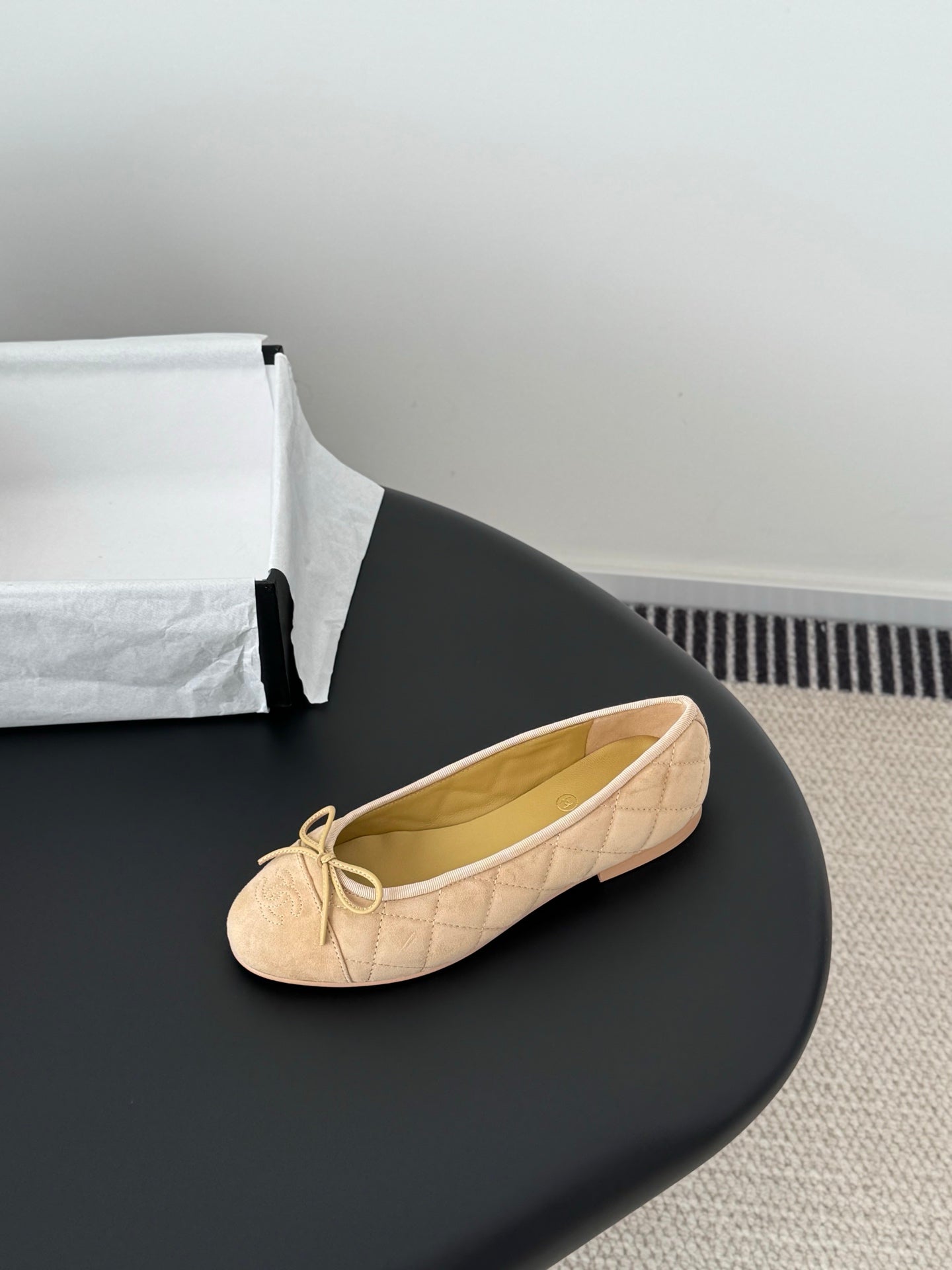Beige quilted ballet flat with bow at toe, round toe and lightly padded sole