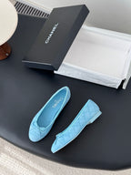 Light blue Chanel ballet flats, front angled view with bow and quilted pattern