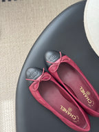 Pink quilted ballet flats with bow laces and black toe cap, close-up