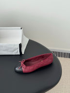 Quilted ballet flat in pink with black toe cap and bow-tied vamp