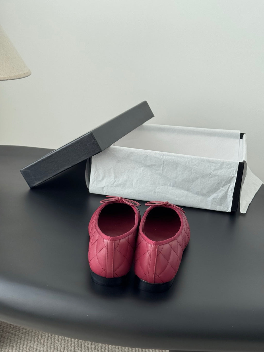 Pink quilted ballet flats with rounded toe and bow detail, black accents