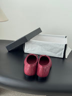 Pink quilted ballet flats with rounded toe and bow detail, black accents