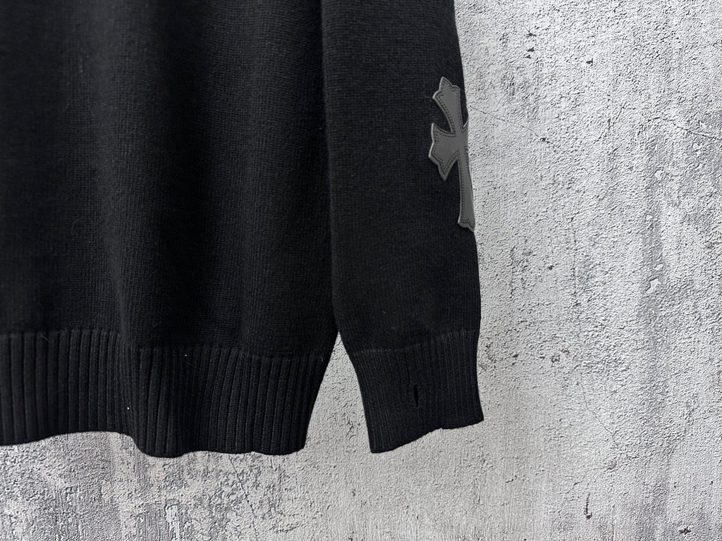 Black knit sweater sleeve cuff with star-shaped applique detail.