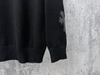 Black knit sweater sleeve cuff with star-shaped applique detail.