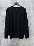 Black long-sleeve knit sweater with ribbed mock neck, cuffs, and hem.