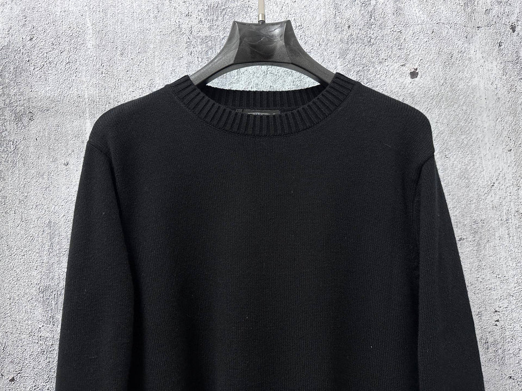 Black long-sleeve knit sweater with ribbed mock neck collar.