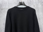 Black long-sleeve knit sweater with ribbed mock neck collar.