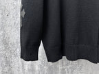 Black knit sweater sleeves with ribbed cuffs and hem.