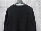 Black long-sleeve knit sweater with decorative stitched panel detail at back.
