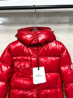 Moncler long red puffer jacket close-up on hood, glossy quilting and front button placket