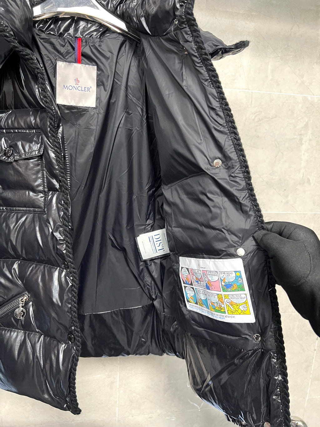 Moncler long puffer jacket side view with hood, glossy black, lining tags and buttons
